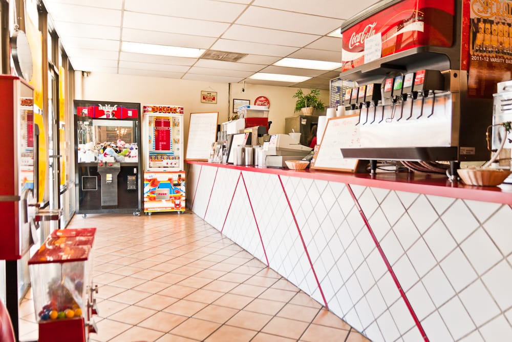 Interior counter at Esperanza Burgers with menu boards, whiteboard specials, and a chef mascot